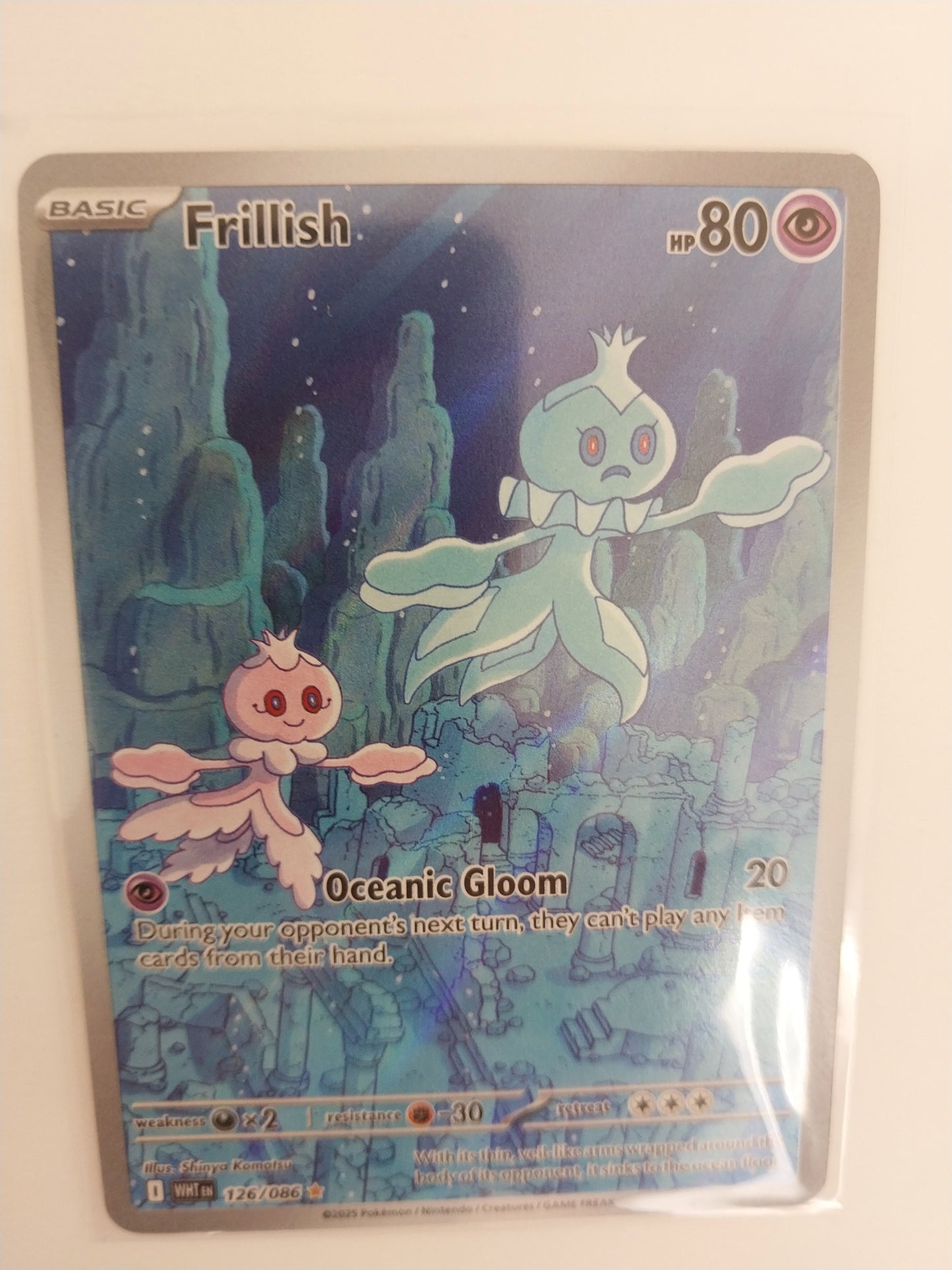 Pokémon trading card featuring Frillish and Oceanic Gloom on a reflective surface.